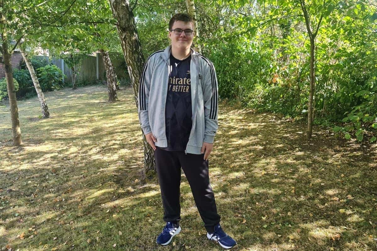 Teenage boy standing in woods wearing adidas clothes