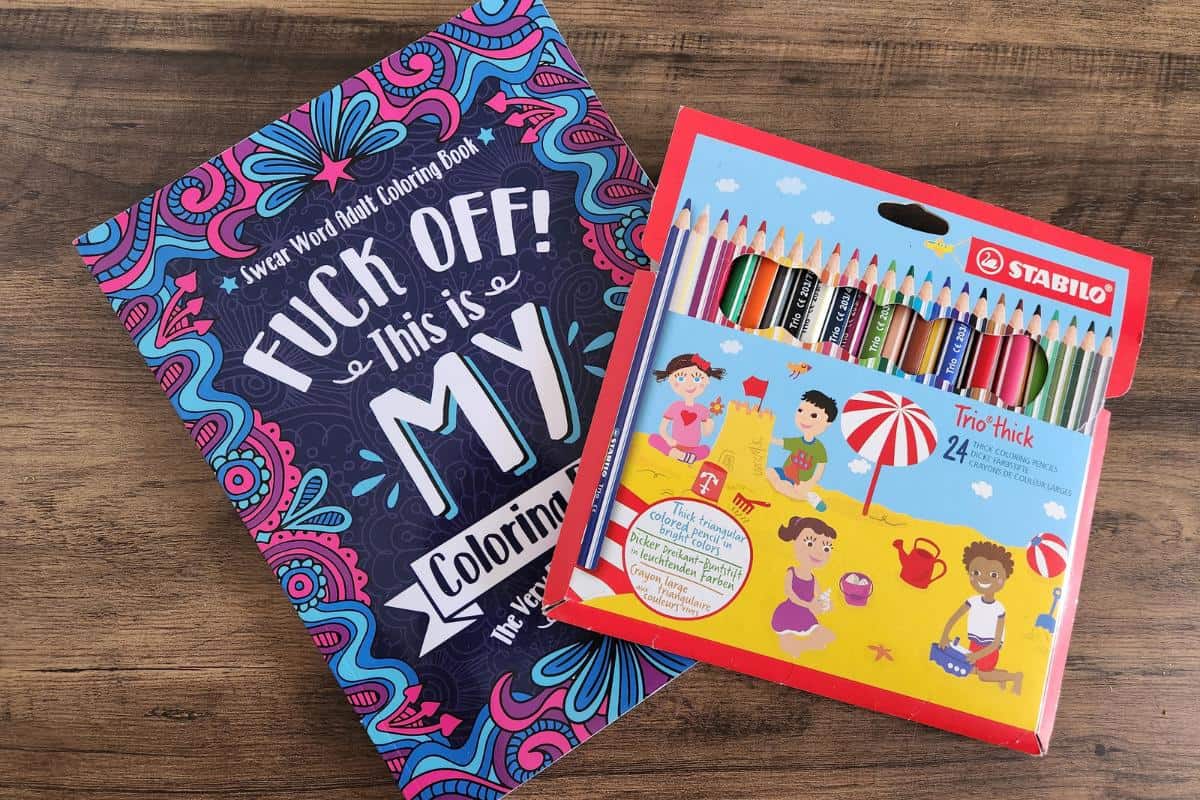 Adult colouring book and coloured pencils.