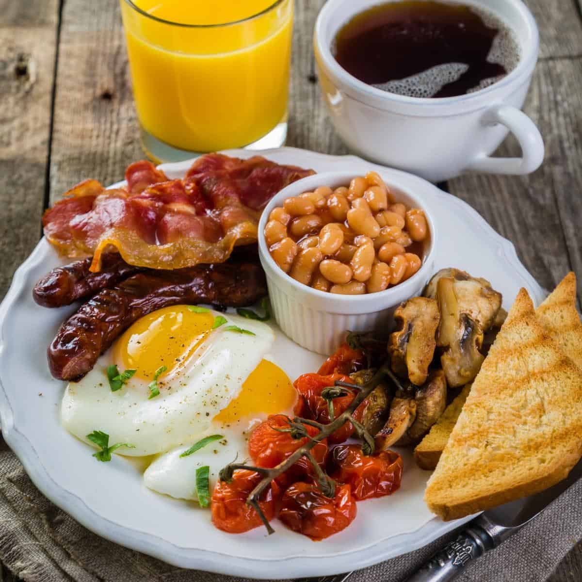 cooked breakfast on a table with coffee and orange juice
