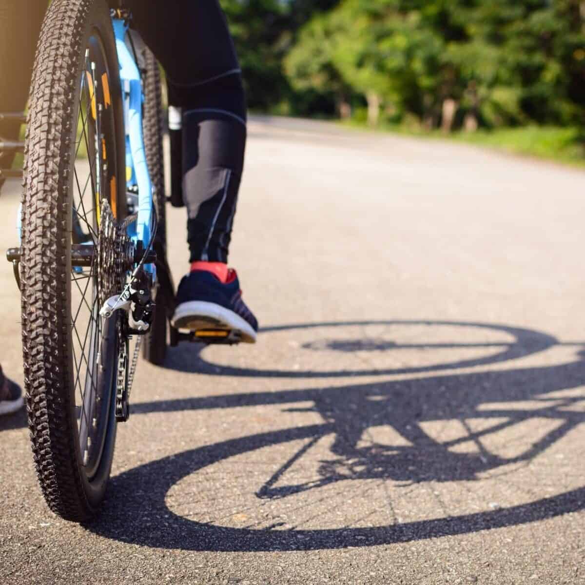person cycling with a shadow of a bike as they cycle to university.