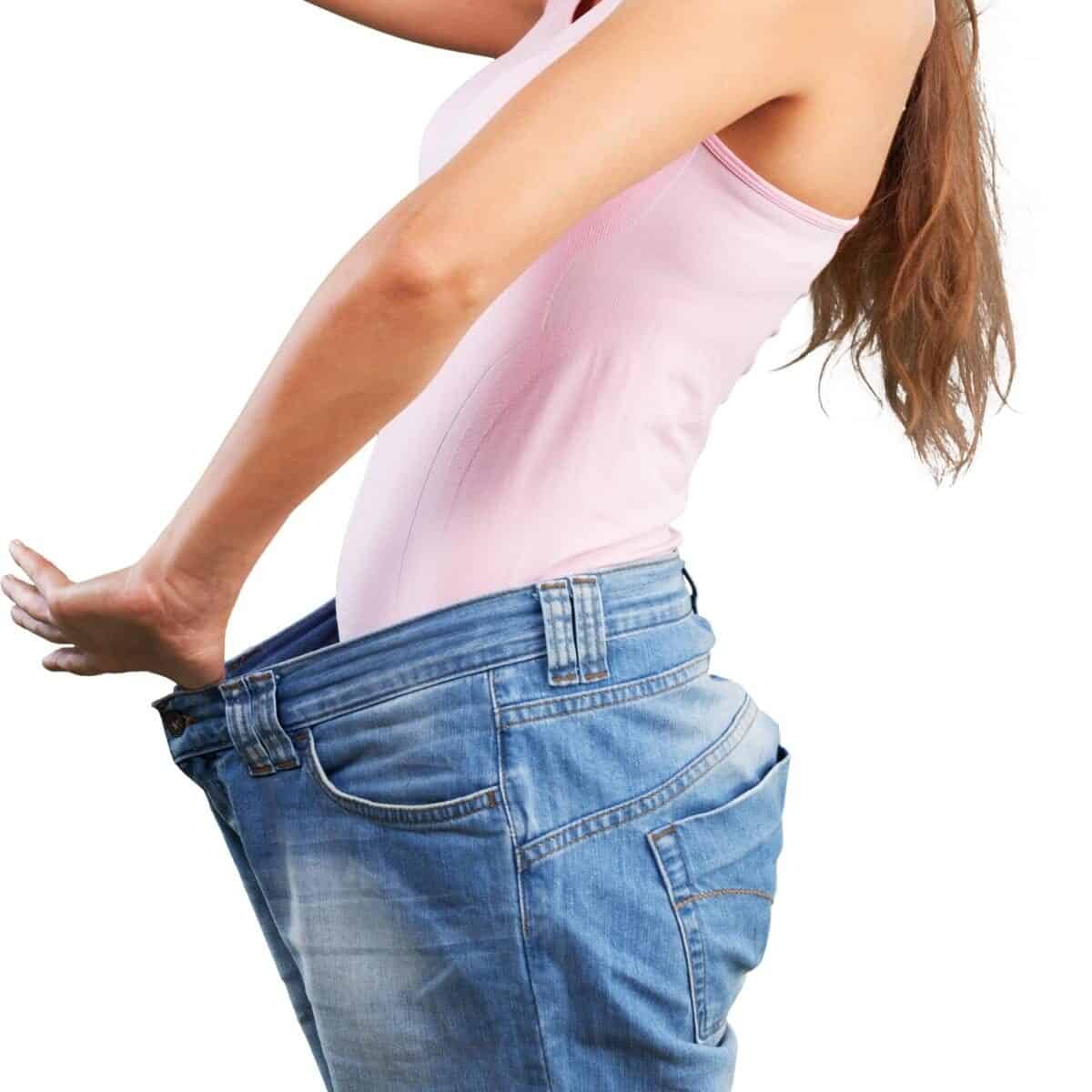 weight loss - lady holding jeans from her body to show weight lost.