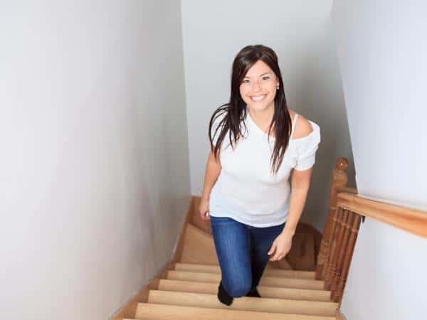Lady walking up stairs make time for workouts by just using the stairs