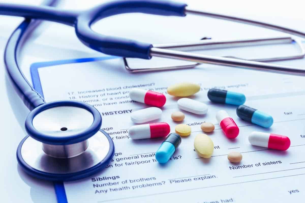 Selection of tablets with a stethoscope on a doctors clipboard with a questionnaire with family history questions.