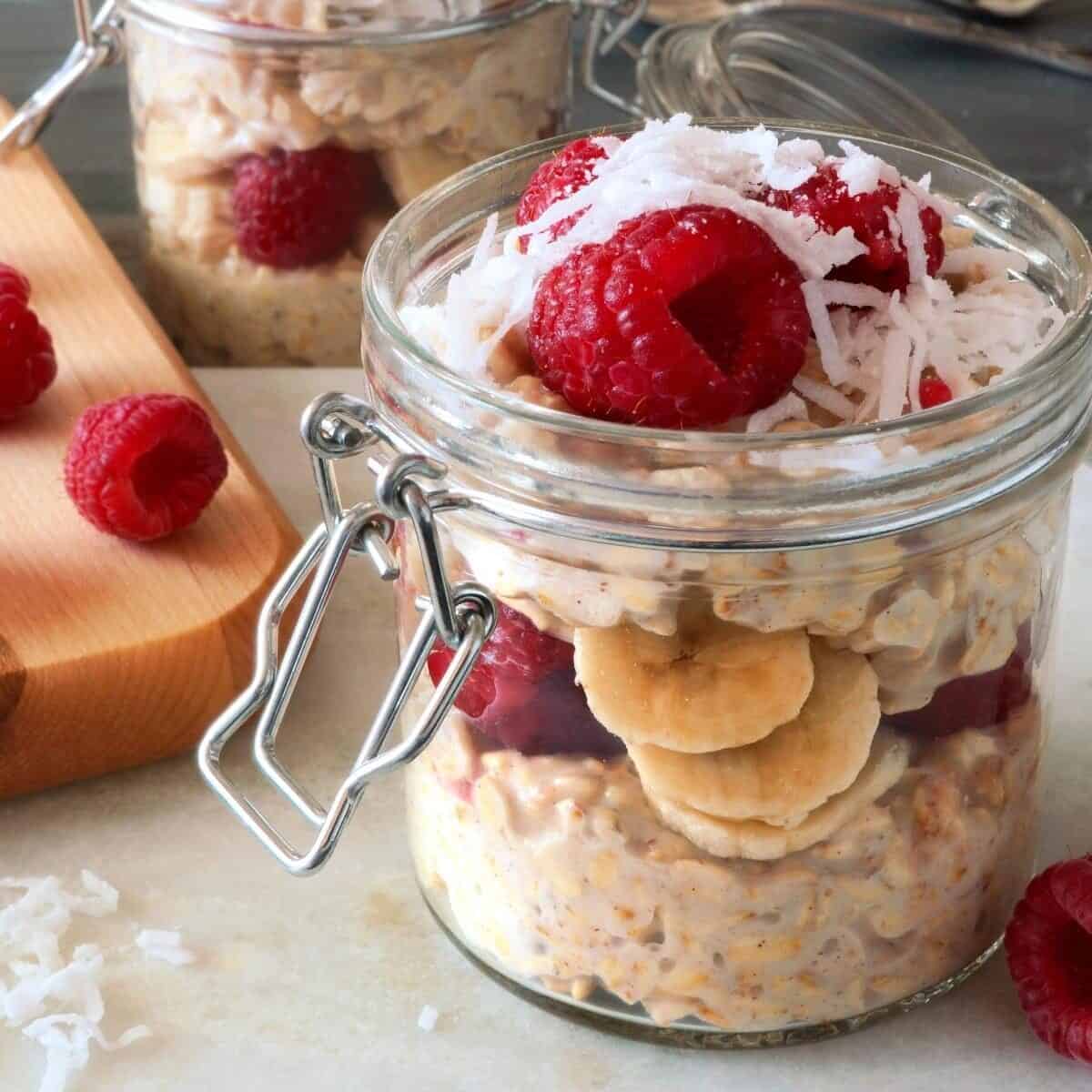 Overnight oats in a mason jar with banana raspberry and grated chocolate