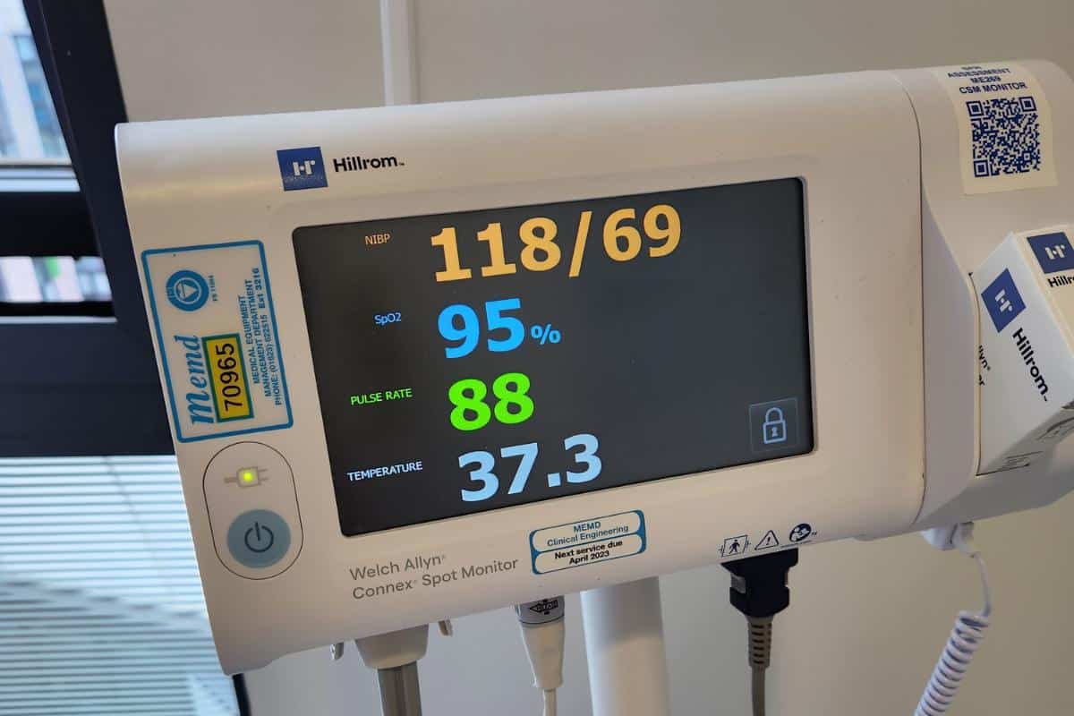 Close-up of a medical monitor showing vital statistics about me: blood pressure (118/69), oxygen saturation (95%), pulse rate (88), and temperature (37.3°C).