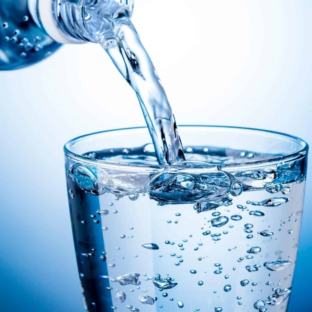 glass of water being poured from a bottle